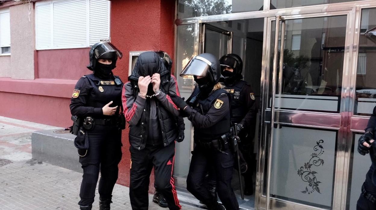 Momento de la salida de uno de los detenidos en la operación.