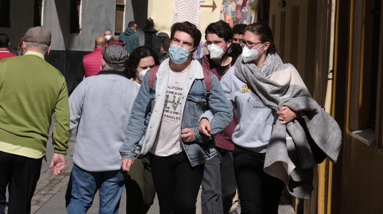 Varios ciudadanos pasean por las calles de Cádiz con mascarilla.