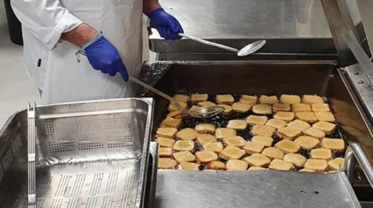 El cocinero elaborando las torrijas que se van a repartir entre los pacientes.