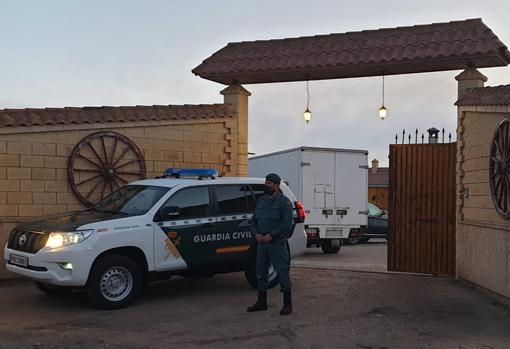 Un agente custodia la entrada de la finca de Carmona donde se efectúa el registrp