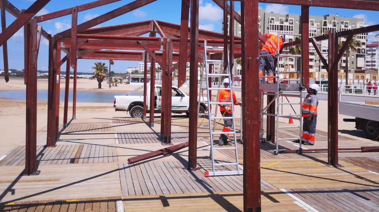 Los operarios de El Puerto instalan varias estructuras en la playa de Valdelagrana.