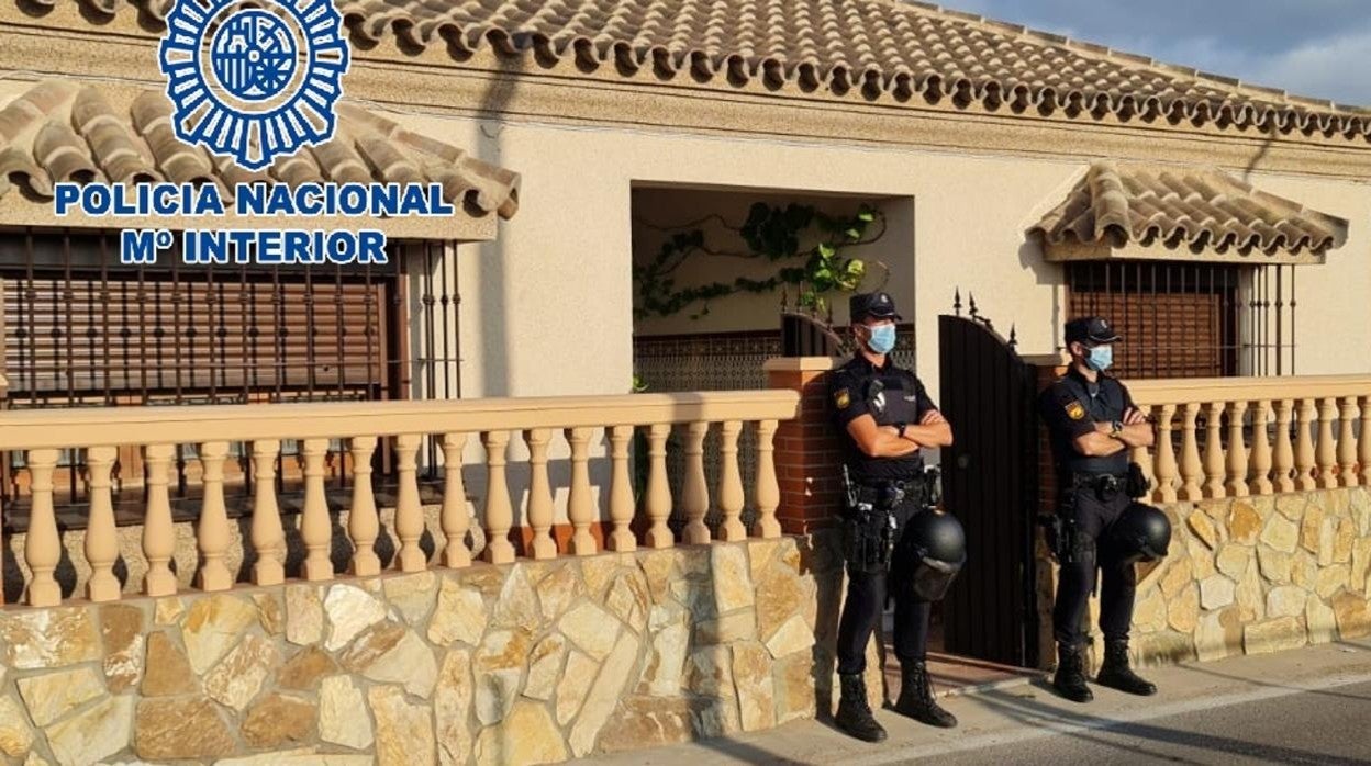 Dos agentes, en la puerta de uno de los registros que se están realizando.