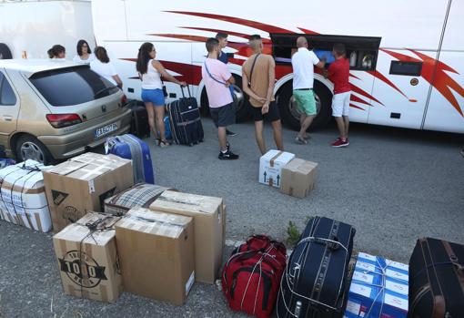 Los jornaleros gaditanos cargan su equipaje en el autobús