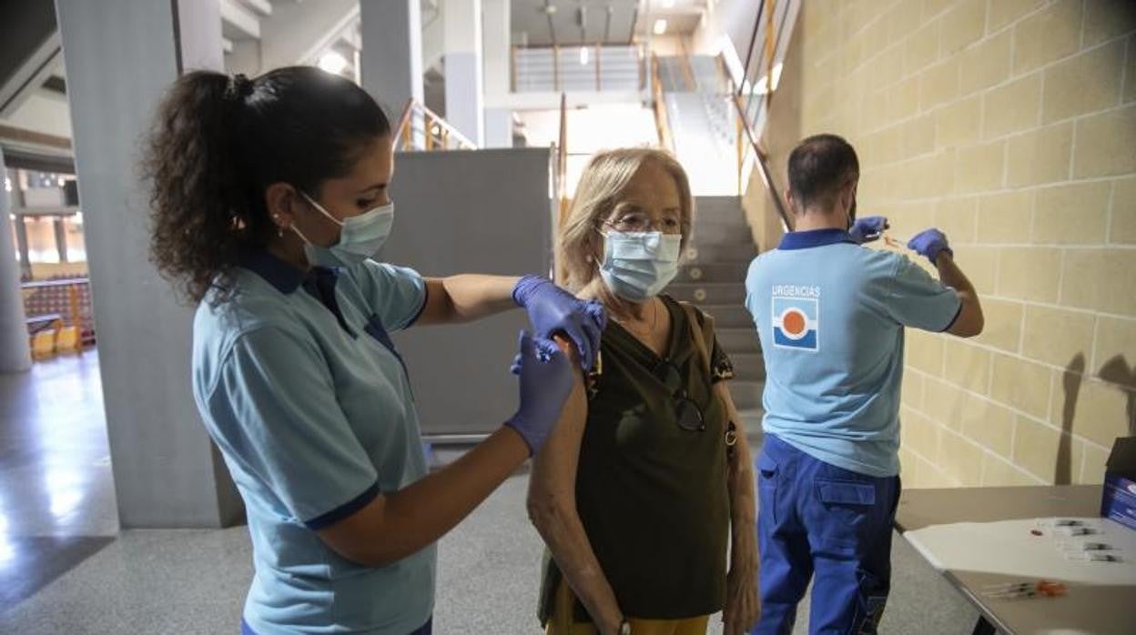 Una enfermera del SAS inocula en el hombro de una mujer la vacuna contra el Covid