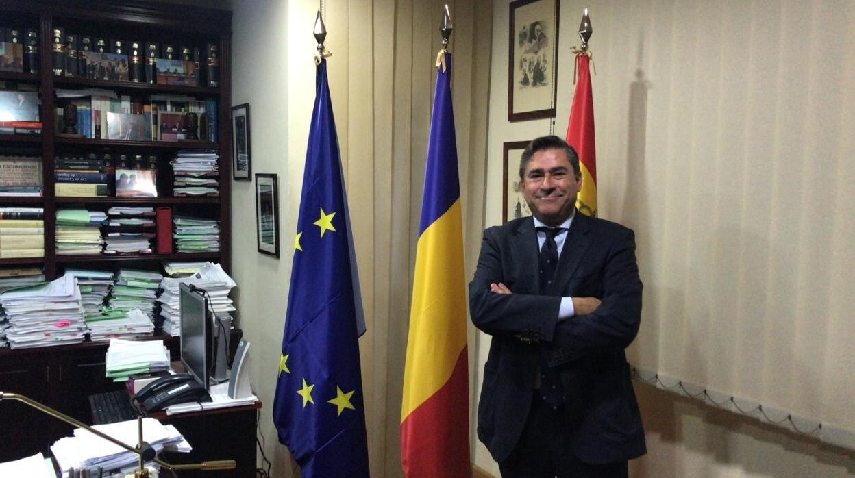 Fernando estrella, en su despacho y junto a las banderas de Europa, Rumanía y España.