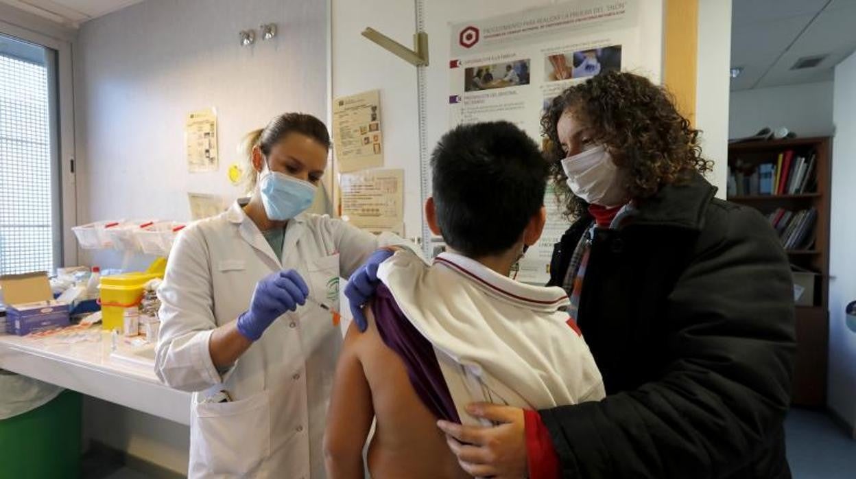 Una enfermera vacuna contra el Covid a un niño ante la presencia de su madre