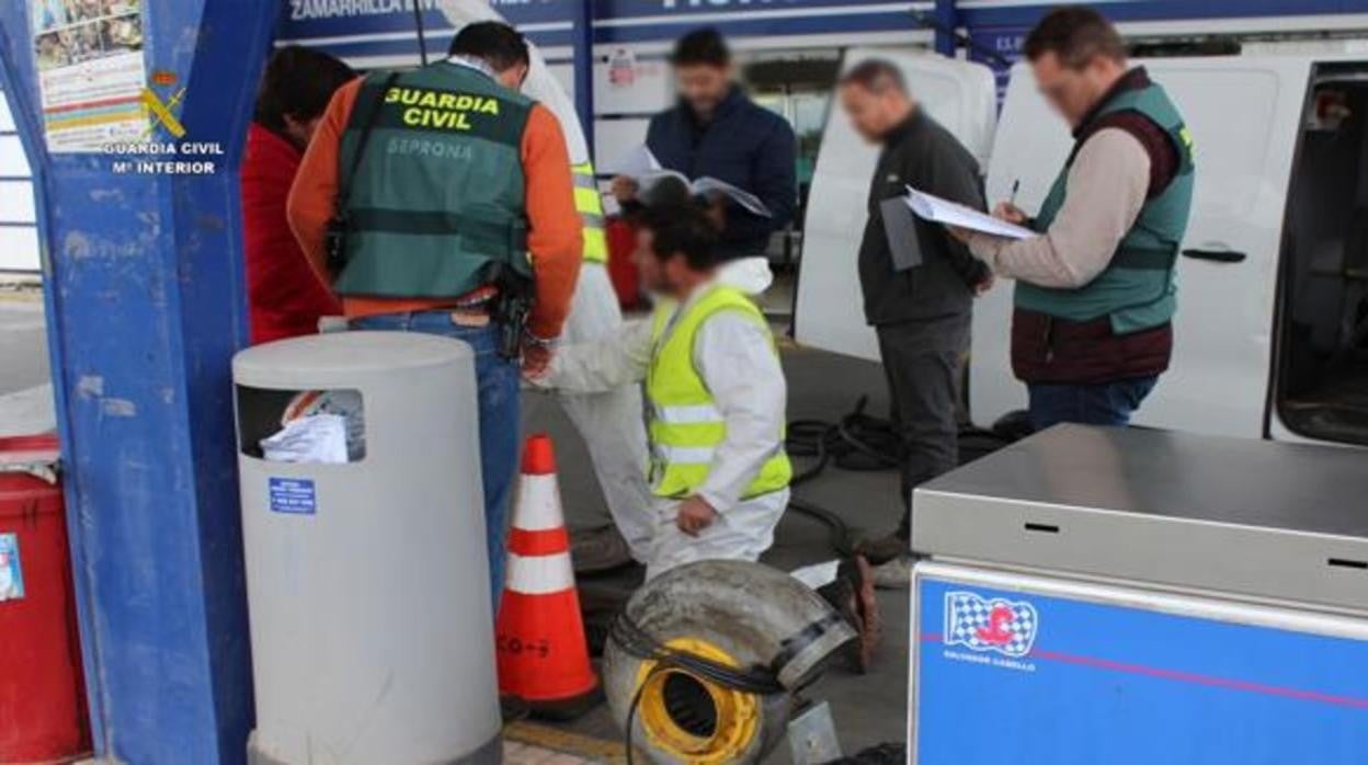 Agentes de la Guardia Civil y técnicos de la Junta de Andalucía durante una inspección a la gasolinera de Coria