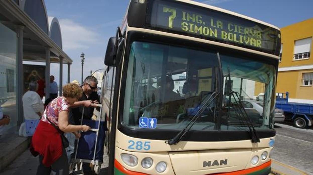 Una pareja de ususarios sube un carro de la compra en el autobús que cubre la línea 7.