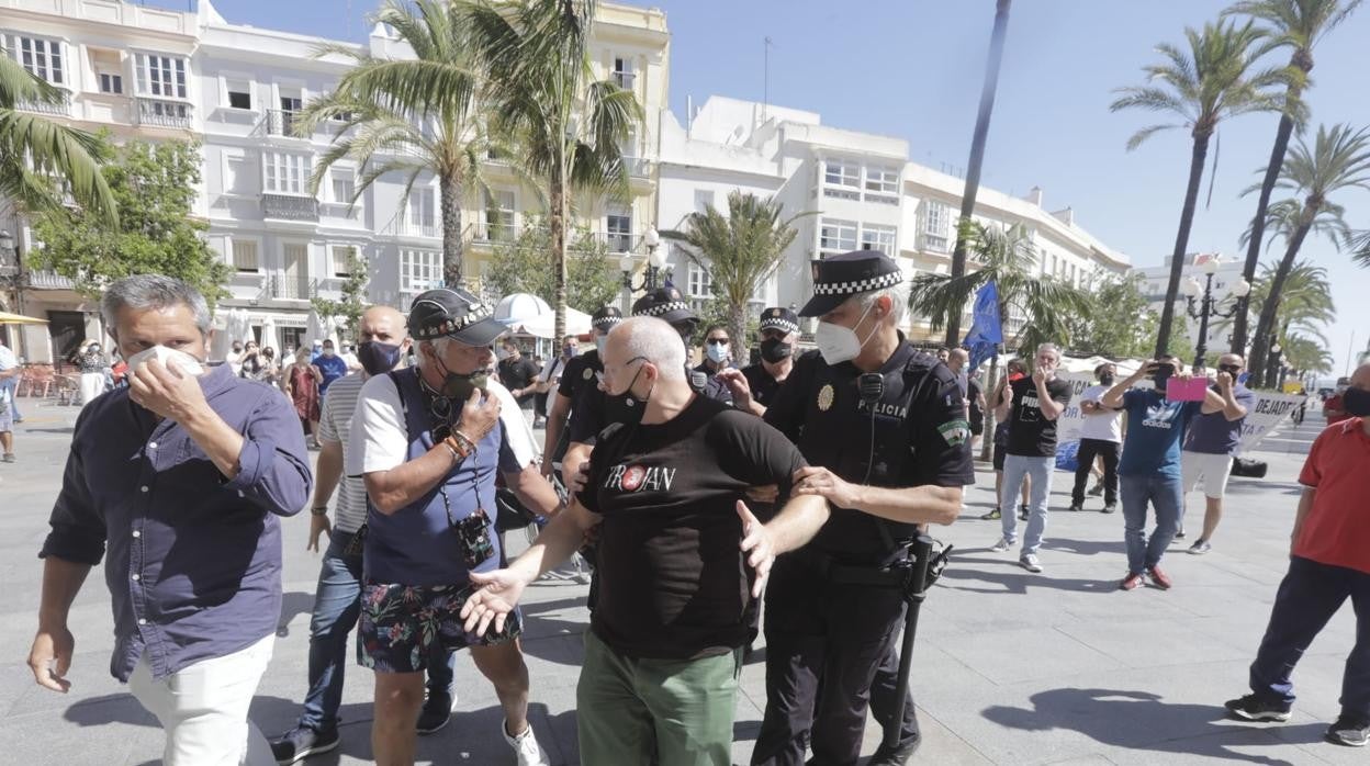 José Vicente Barcia, tras una discusión con sindicatos policiales en una protesta frente al Ayuntamiento, retirado por un agente.