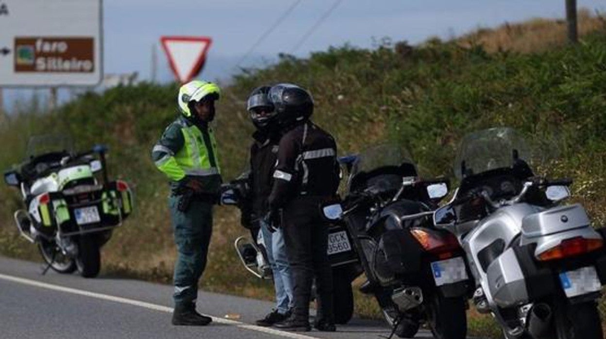 Un agente de la Guardia Civil dialoga con dos motoristas