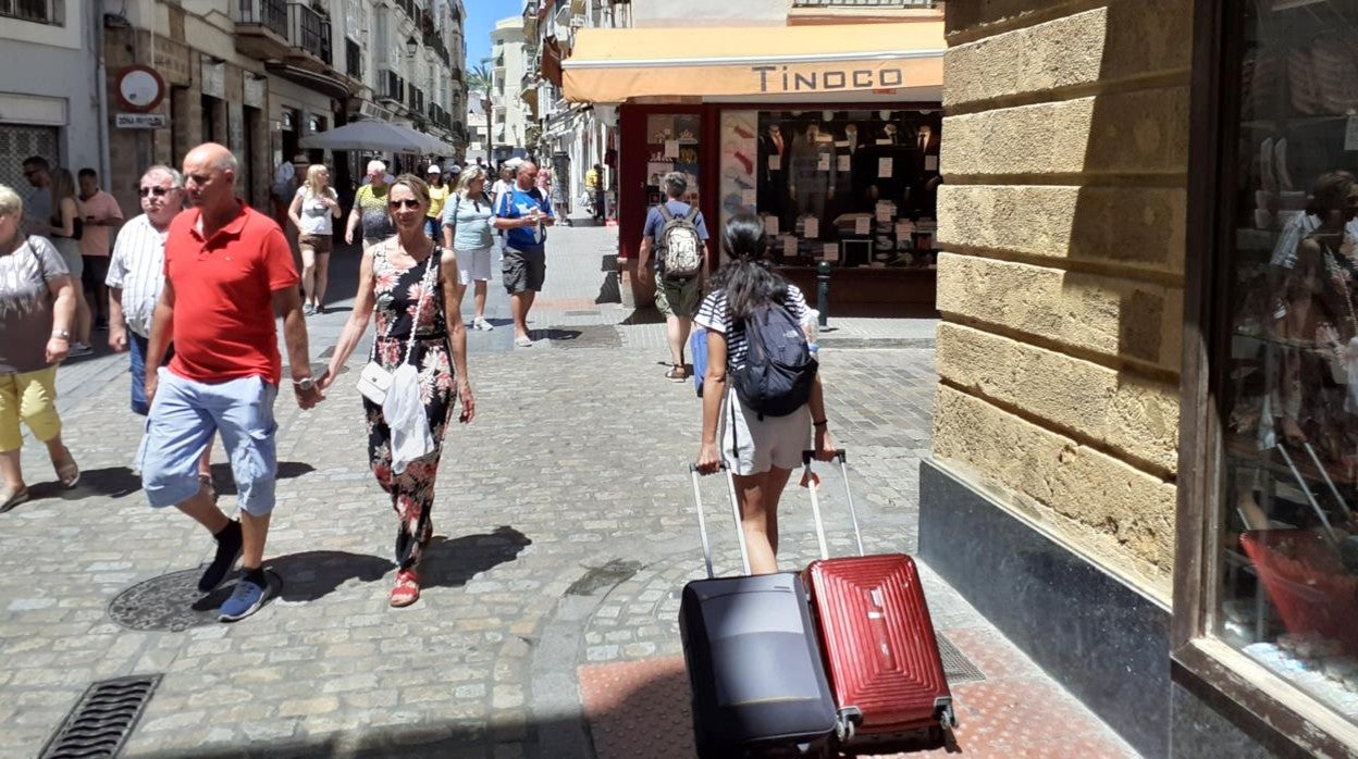 Una turista pasea por las calles de Cádiz capital, llenas de gente.