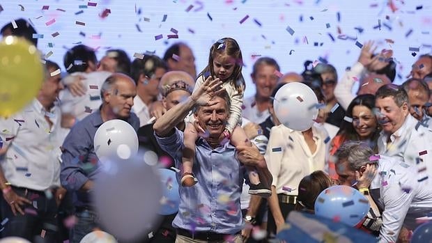 El presidente electo de Argentina, Mauricio Macri (c), saluda a seguidores cargando sobre sus hombros a su hija Antonia