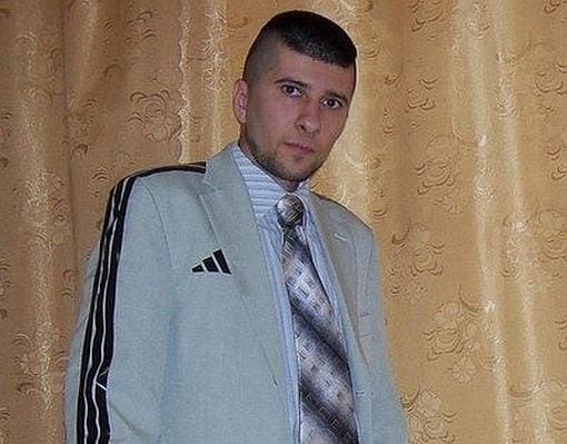 Imagen de un joven ruso con un traje con el logo Adidas