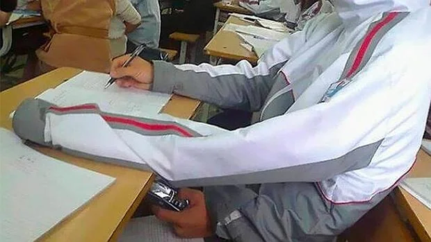 Un estudiante copia utilizando un brazo extra