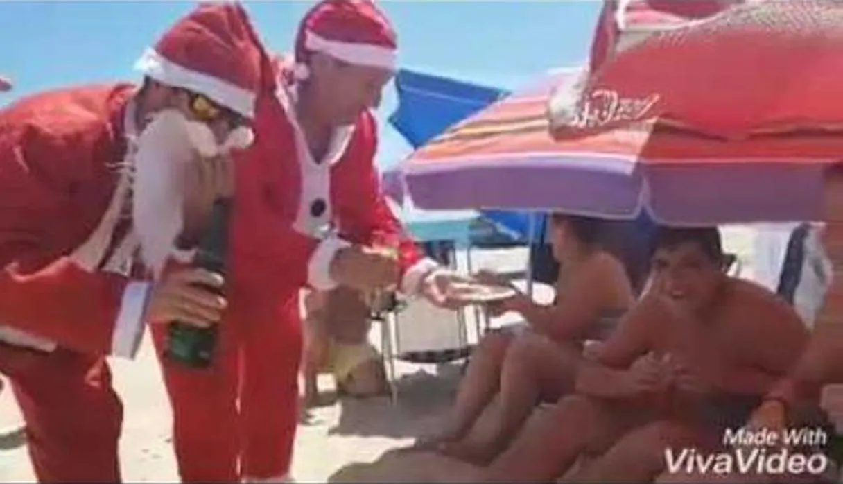 Papá Noel llega a pleno sol y a 40 grados a una playa de Huelva para repartir polvorones