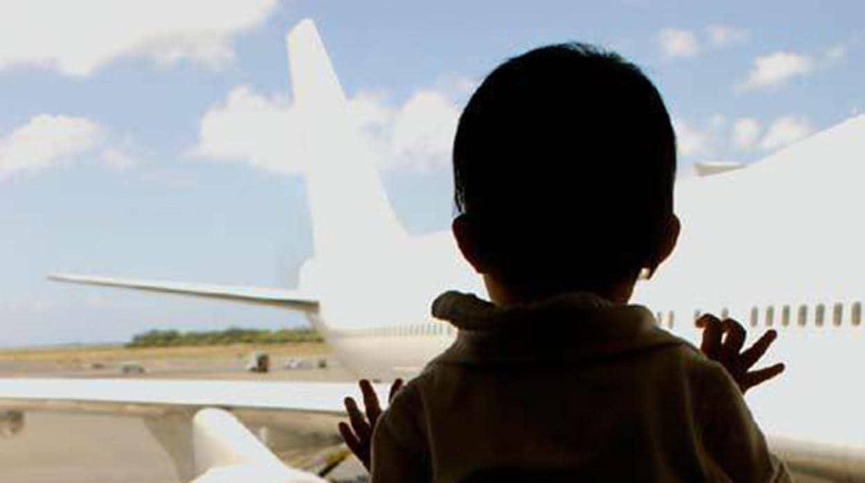 Un niño pequeño mirando un avión