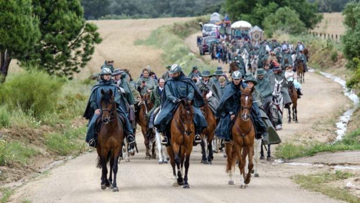 Tres guardias civiles a caballo abren paso al Simpecado de la Matriz de Almonte en la lluviosa Romería de 2016
