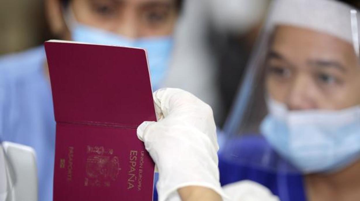 Españoles repatriados muestran su pasaporte