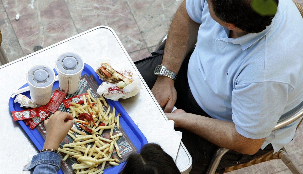 Dos adultos comiendo alimentos ultraprocesados