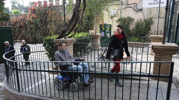 Antonio Hierro sube por una rampa con su silla de ruedas, en un recorrido por los Jardines de Murillo, en compañía de Sara López