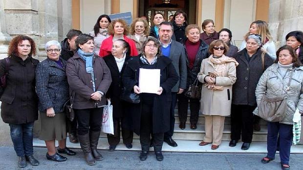 Teresa García, con un documento en la mano, junto a Juan Espadas protestando contra el PP por cerrar los PIM