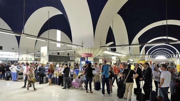 Pasajeros en una cola de facturación en el aeropuerto