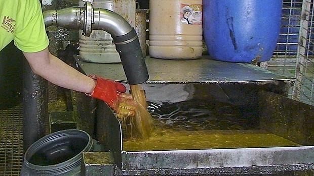 Un operario, reciclando el aceite de cocina usado