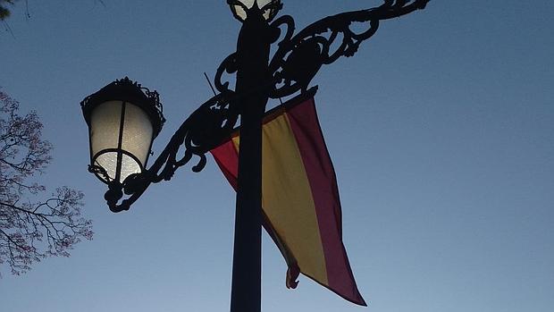 La bandera de España ondea desde una farola fernandina de la Puerta de Jerez