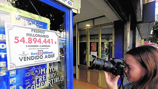 Una reportera ayer ante la administración de lotería que repartió el premio en la calle San Jacinto