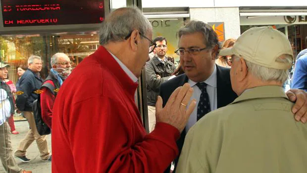 El portavoz del PP en el Ayuntamiento de Sevilla, Juan Ignacio Zoido, con vecinos en una parada de Tussam