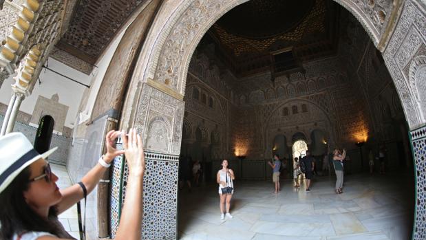 Una turista fotografía un detalle de una sala del Real Alcázar