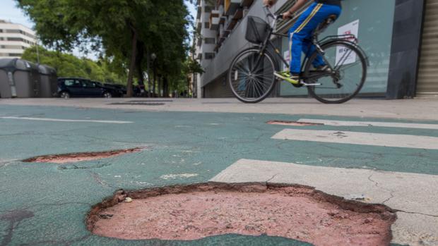 El carril bici cumple diez años con baches, grietas y socavones