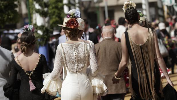 Ún grupo de jóvenes vestidas de flamenca por el Real