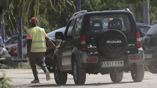 Un aparcacoches africano acompaña al vehículo