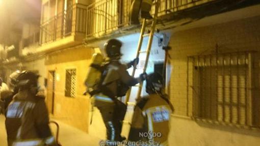 Los bomberos accediendo a la vivienda por el piso superior