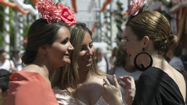 Un grupo de jóvenes conversan en el Real de la Feria