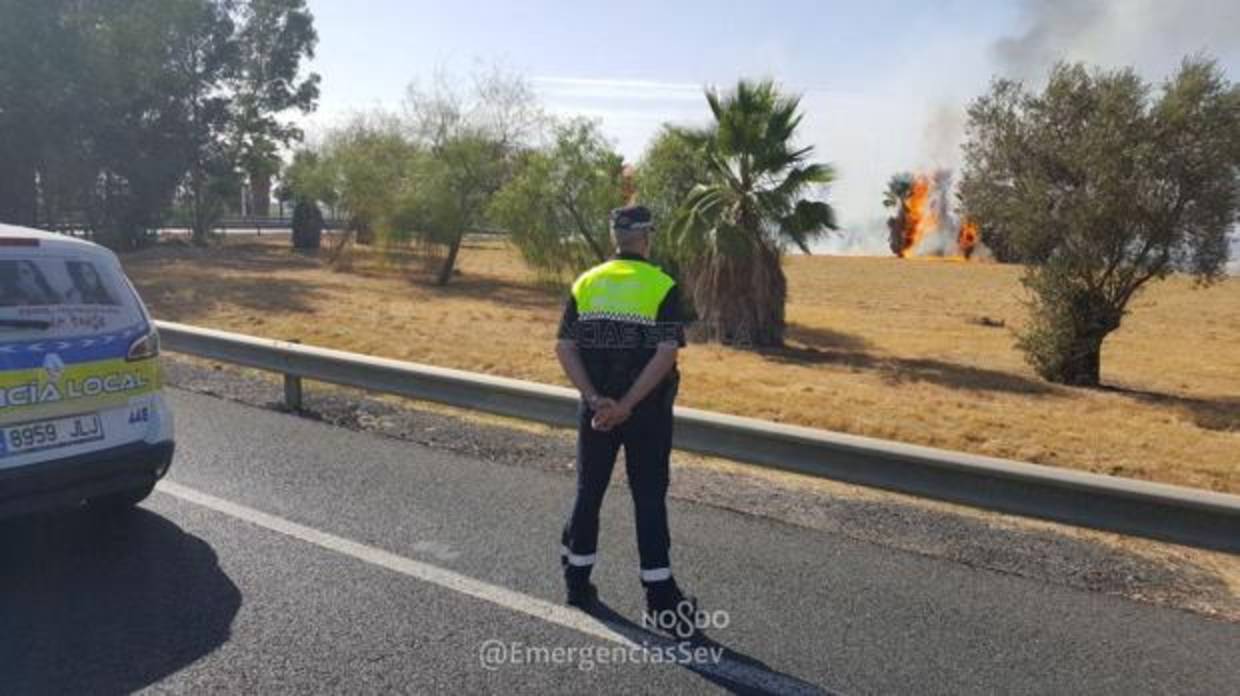 Un policía vigila la carretera afectada por el corte de tráfico