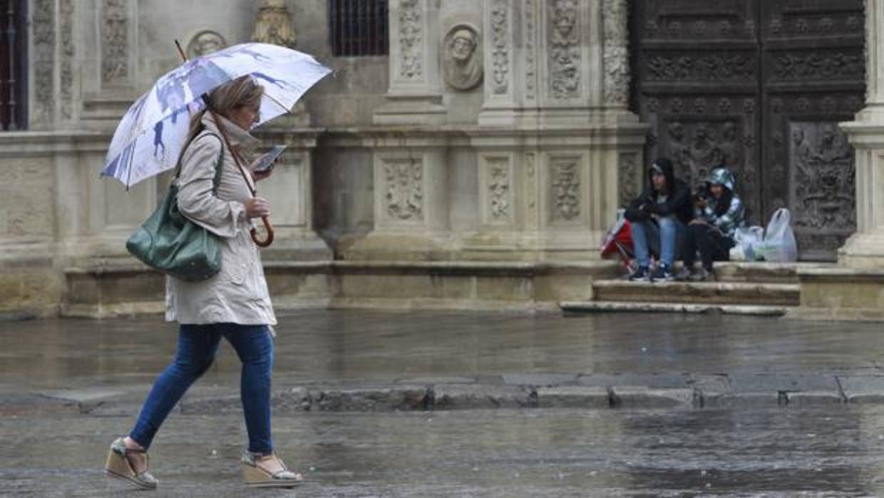 Una mujer se protege de la lluvia con un paraguas