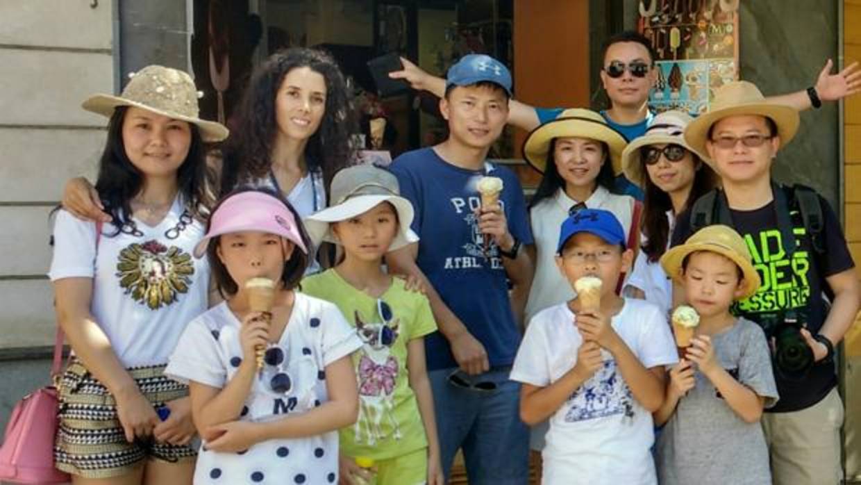 Clara Leal junto a un grupo de chinos mientras se toman un helado este verano en Sevilla