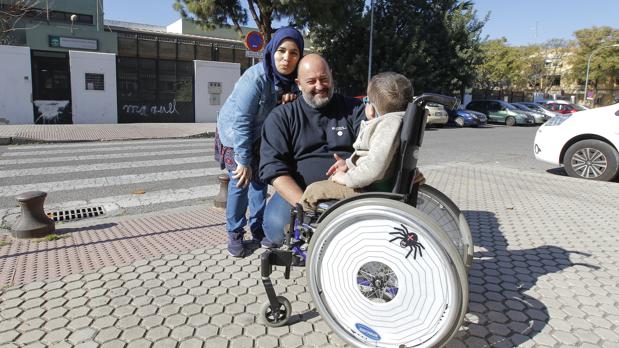 Karim en su silla de ruedas con sus padres delante del colegio Emilio Prados