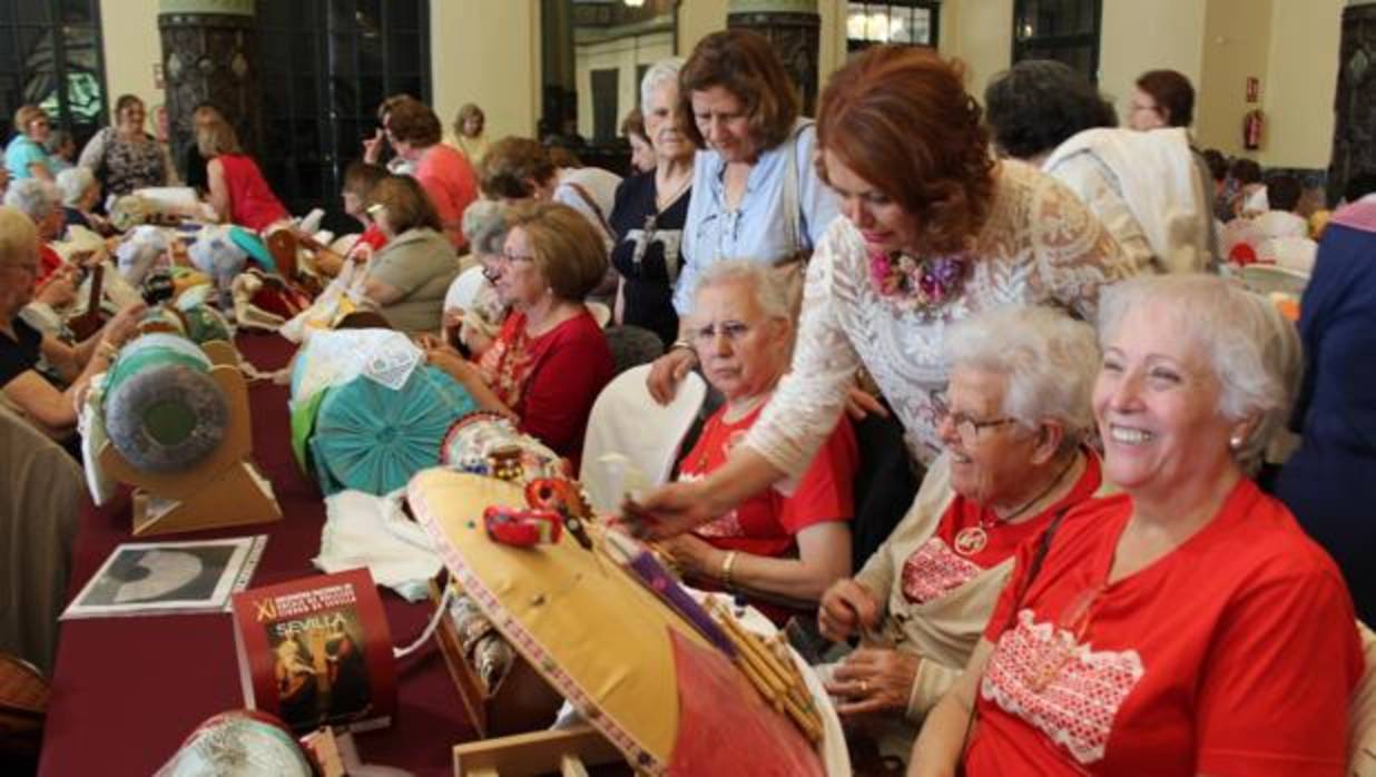 La delegada de Participación Ciudadana, Adela Castaño observa el trabajo de encajeras de bolillos