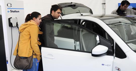 Dos jóvenes se interesan por un coche eléctricos