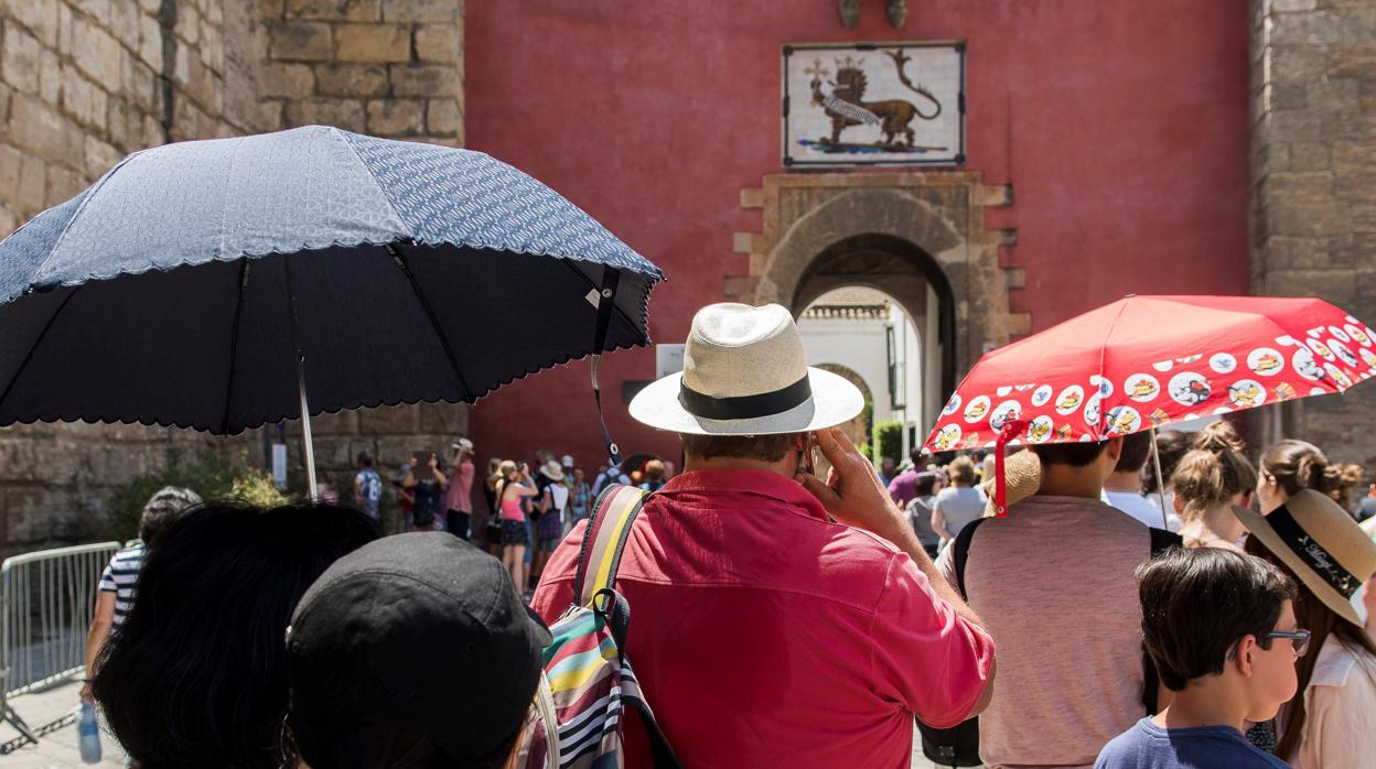 Varios turistas ante la puerta del Alcázar de Sevilla