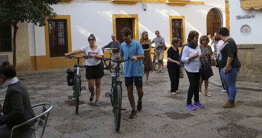 Turistas con bicicleta por la calle Vida