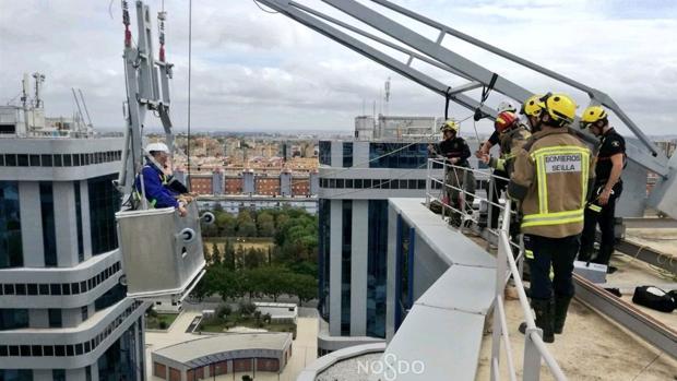 Rescatados dos operarios que quedaron atascados en una grúa en la planta novena de un edificio en Sevilla