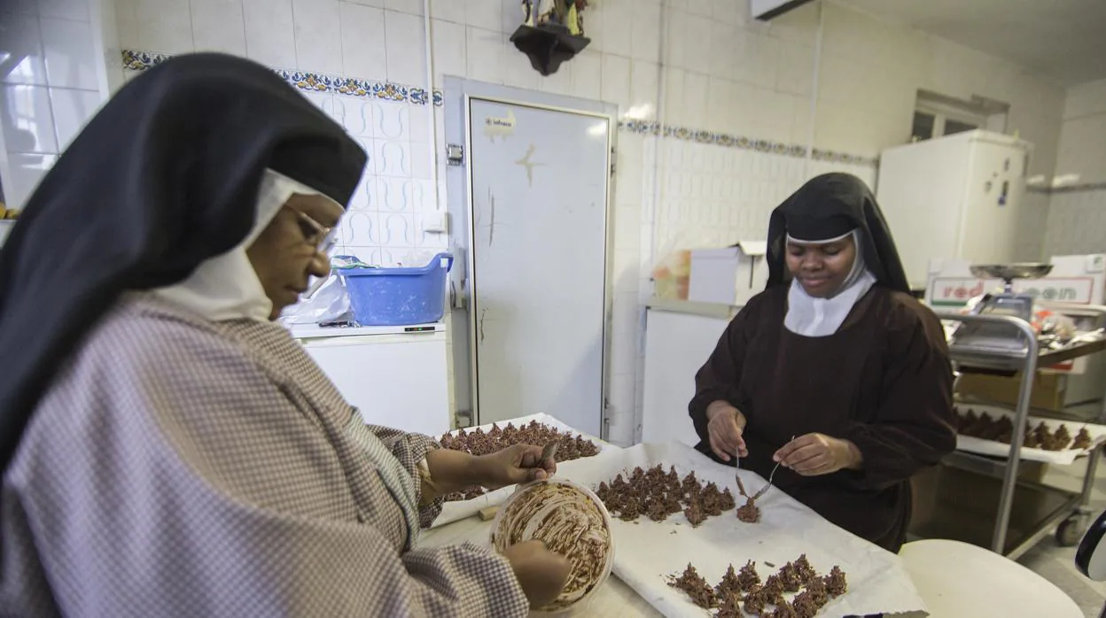 Dos religiosas de la congregación, elaborando los almendrados de chocolate