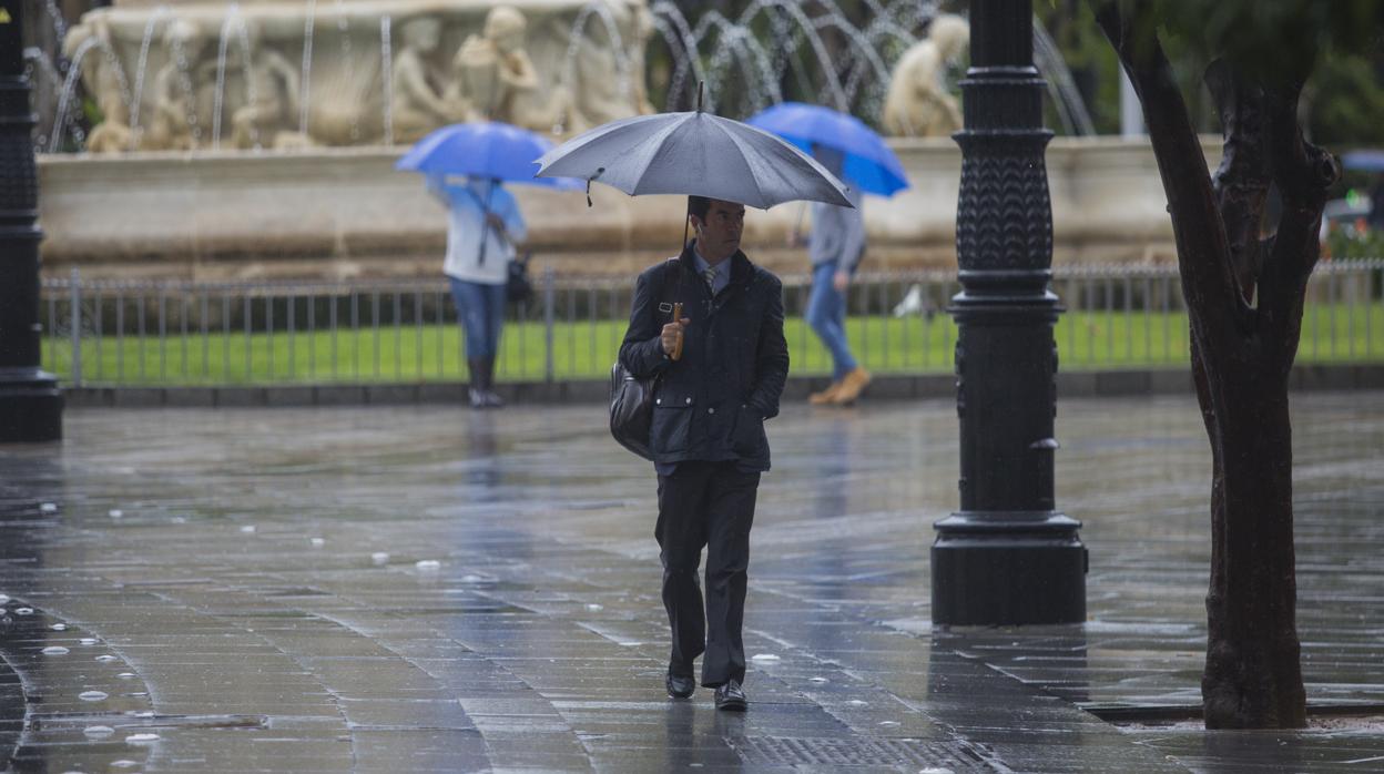 Un hombre se protege de la lluvia bajo su paraguas