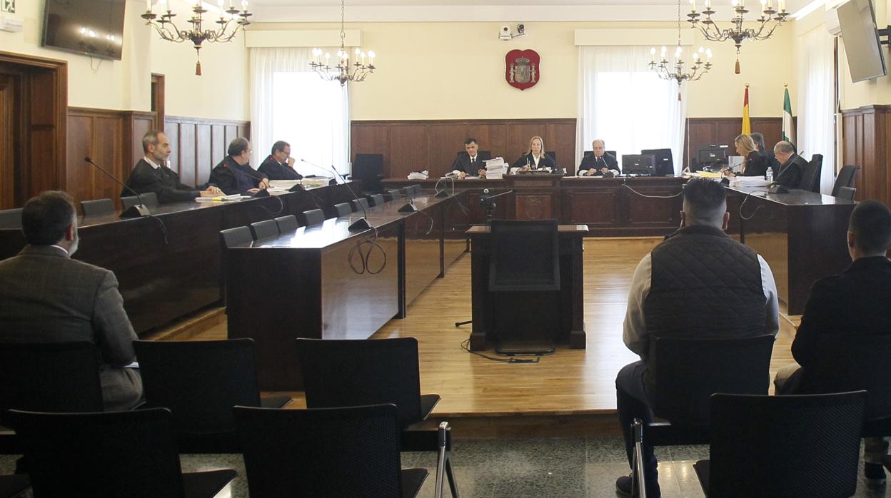 Casimiro Villegas sentado en el banquillo a la izquierda y los acusados del asalto, a la derecha