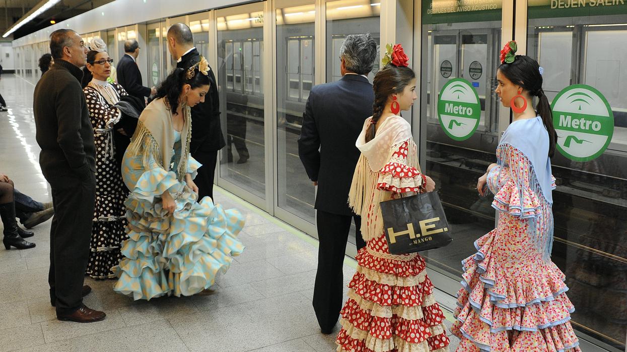 Personas esperando en la parada de metro para ir a la Feria de Abril