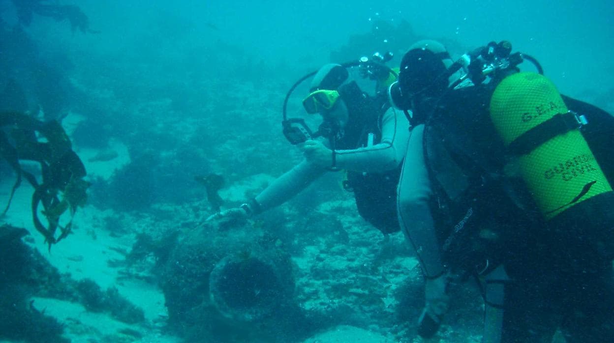 Una pareja de buzos rastrean la zona de un yacimiento subacuático